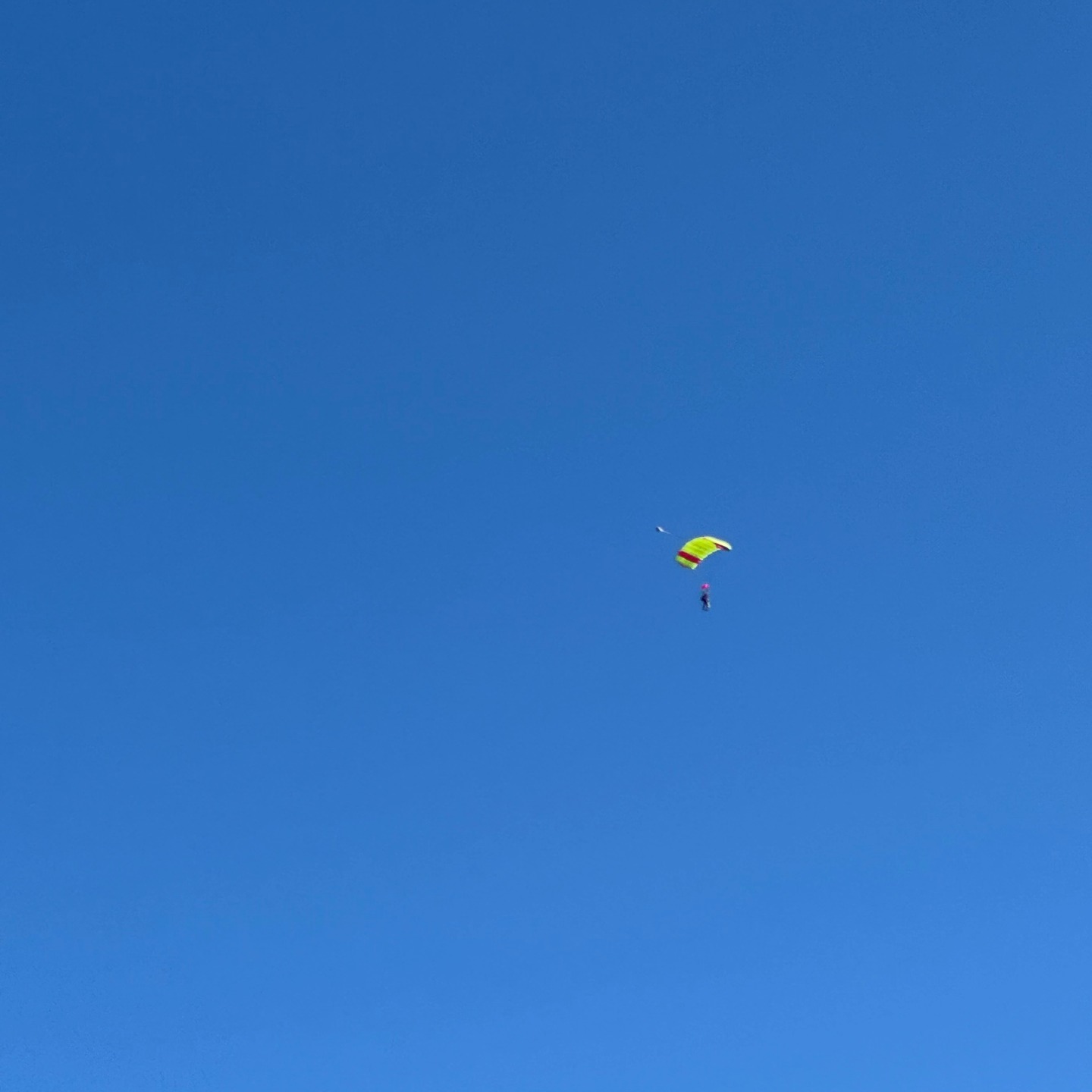 Fallschirmspringerin am blauen Himmel