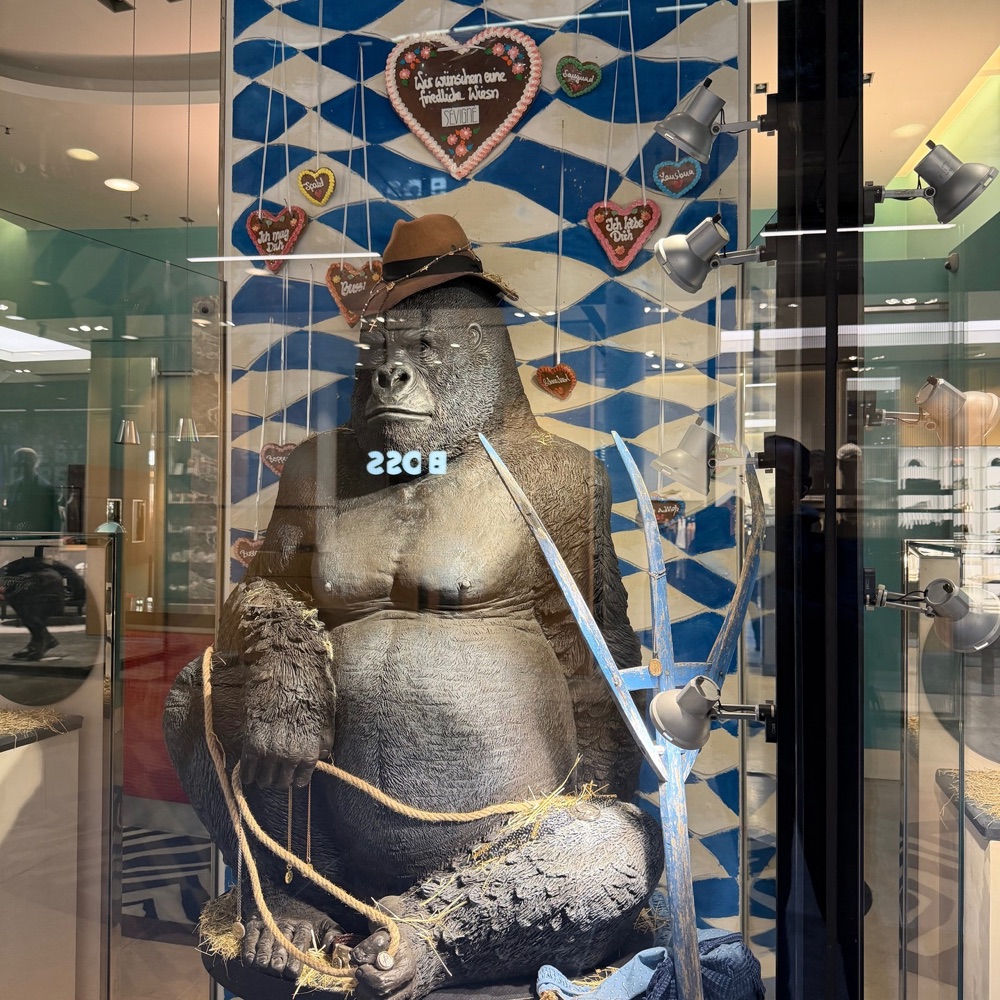 Schaufenster mit einem Gorilla mit Hut vor bayerischer Rautendeko