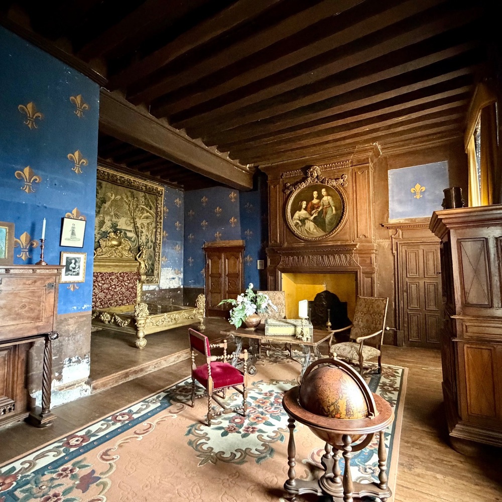 Historisch eingerichteter Raum mit blauen Wänden und Lilienmuster im Château du Bouchet