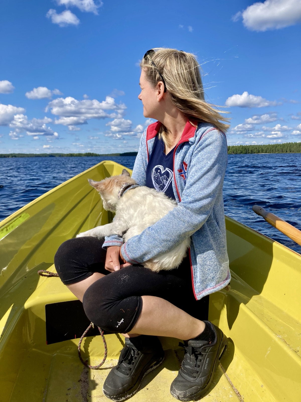 Saskia sitzt mit Lou auf dem Schoß in einem gelben Ruderboot auf dem See