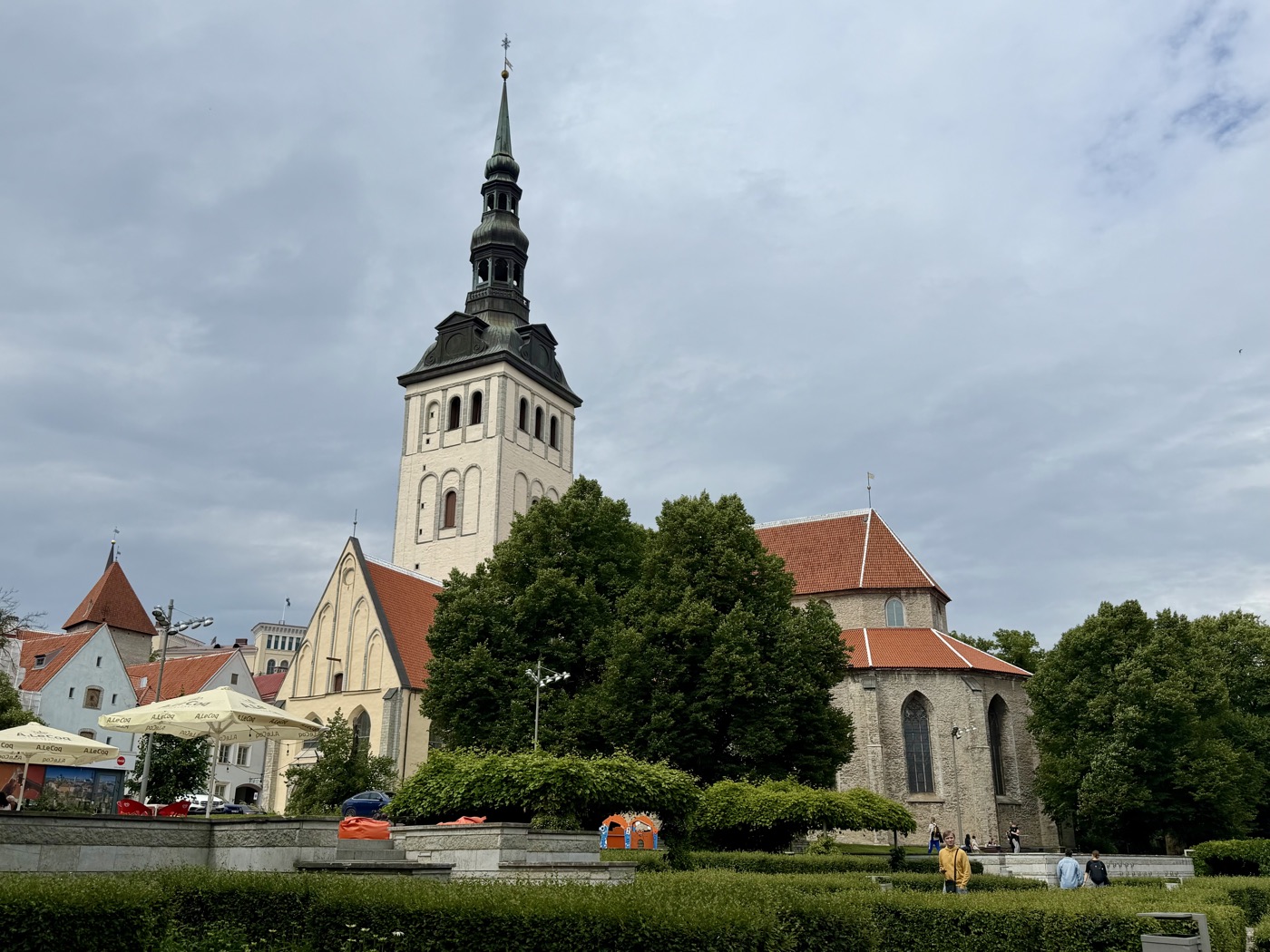 Nikolaikirche mit Turm, davor ein Platz mit Wiese und einigen Menschen