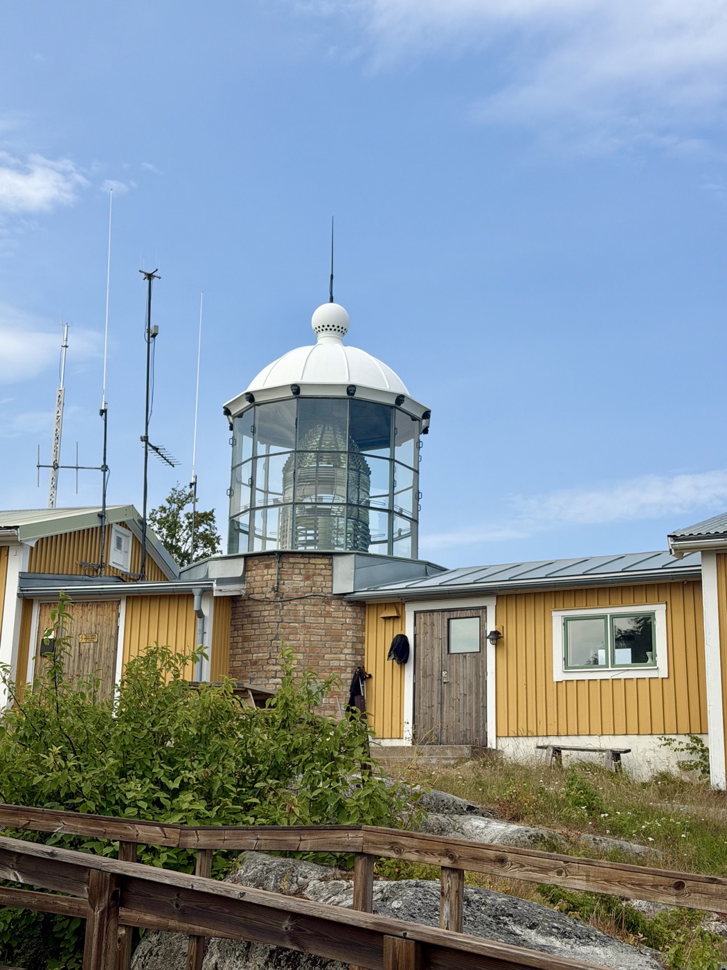 Leuchtturm von Bjuröklubb mit gläserner Laterne über den gelben Wärterhäusern