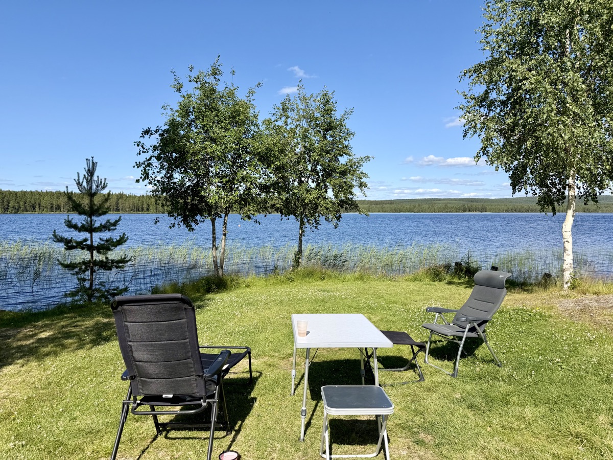 Campingstühle und Tisch auf der Wiese am See bei Fredrika