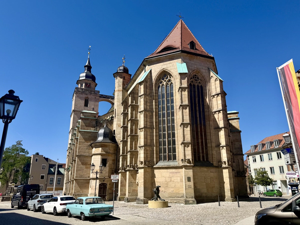 Gotische Stadtkirche mit hohen Fenstern und Turm unter blauem Himmel