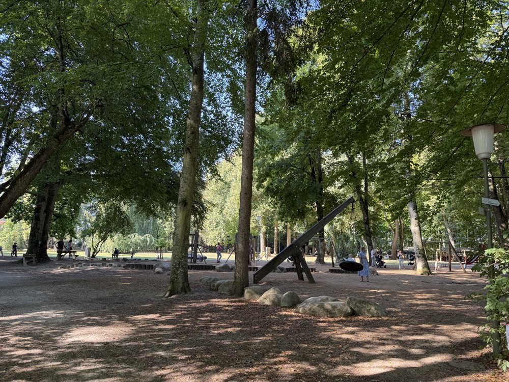 Schattiger Spielplatz unter hohen Bäumen im Luitpoldpark