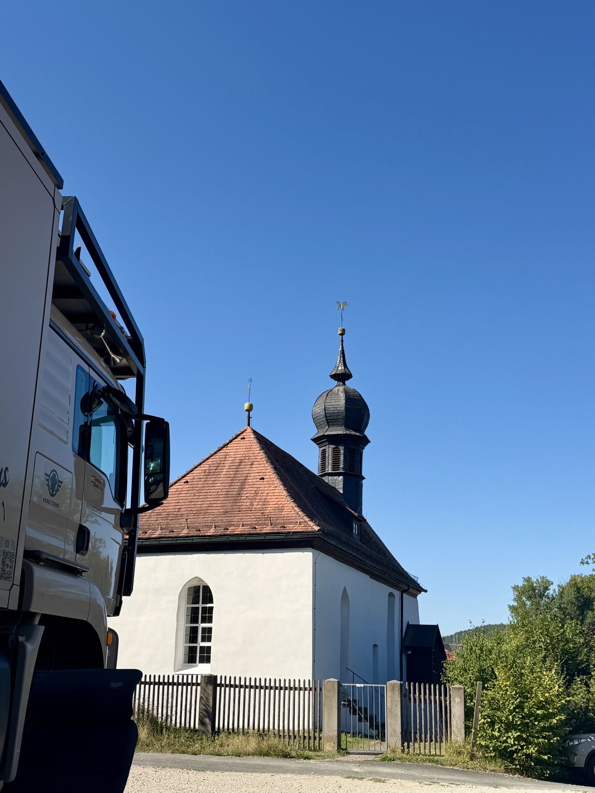 Kleine weiße Kapelle mit Zwiebelturm neben dem Mammothon vor blauem Himmel
