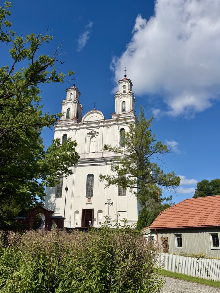 Weiße Barockkirche mit zwei Türmen vor blauem Himmel