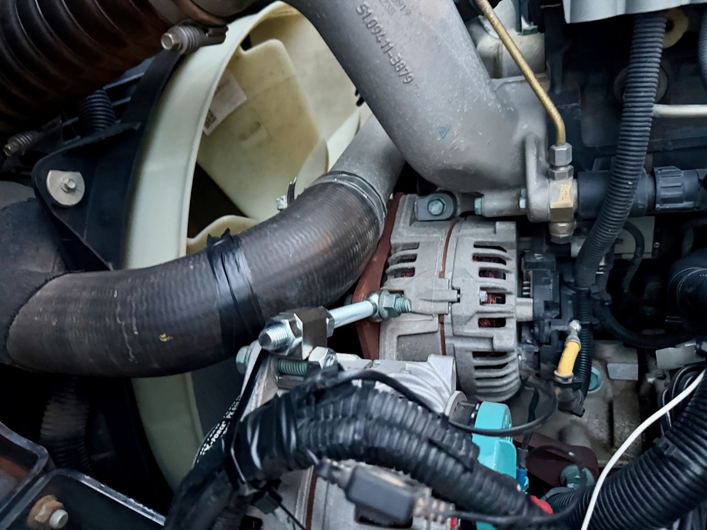 Blick in den Motorraum auf die Lichtmaschine mit neuer Halterung